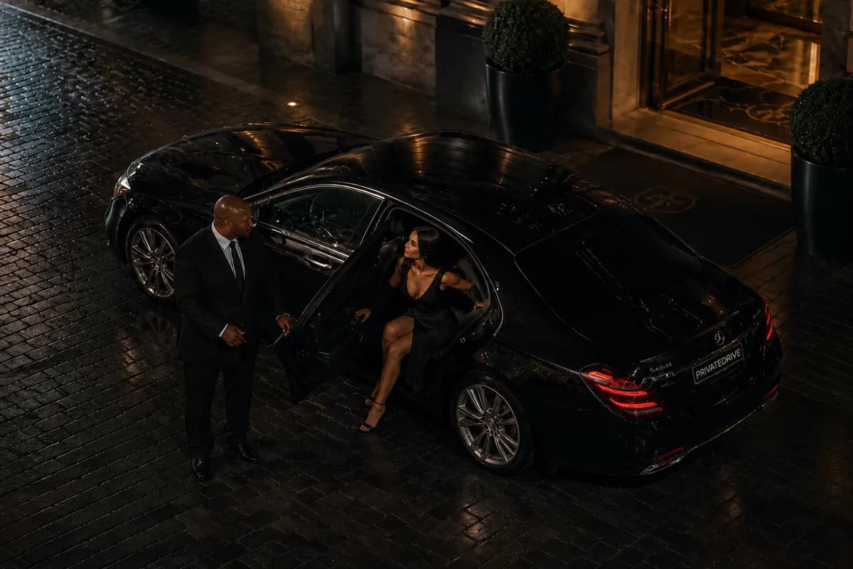 Cliente sortant d'une Mercedes Classe S la nuit devant un hôtel parisien